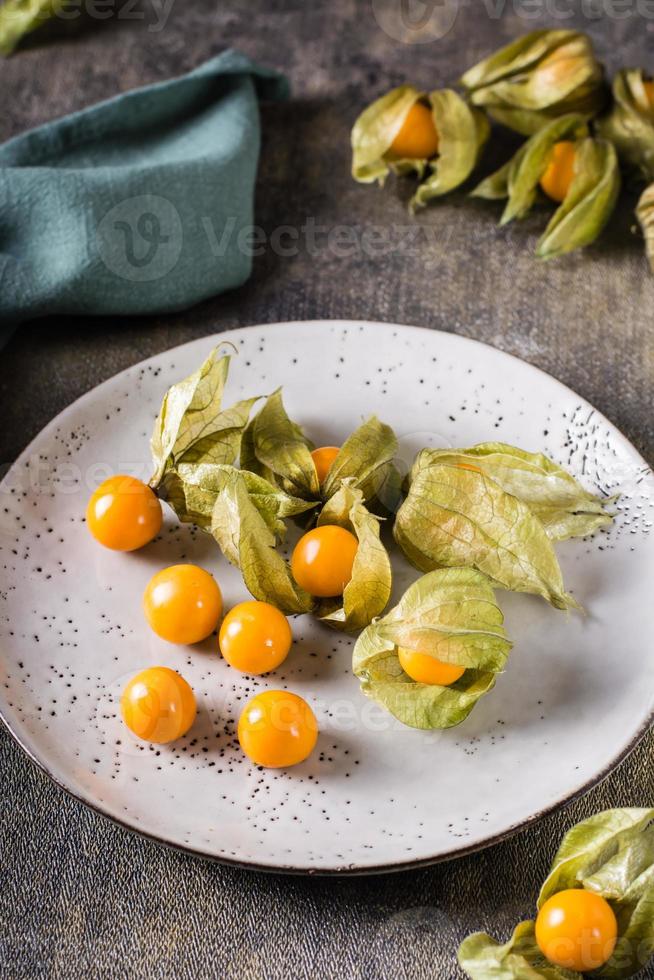 groselha de capa de fruta madura em um prato. nutrição vitamínica exótica. visão vertical foto