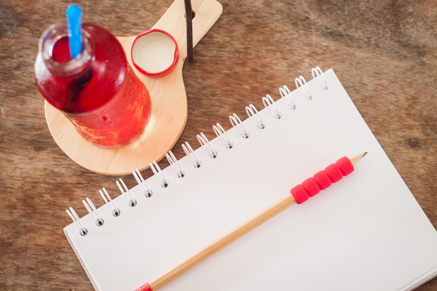 garrafa de suco vermelho com um notebook foto