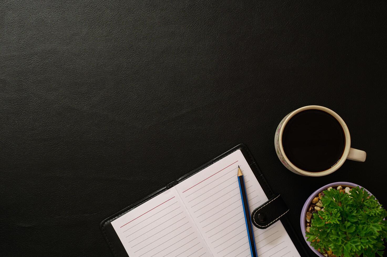 mesa preta com café e ferramentas de escritório foto