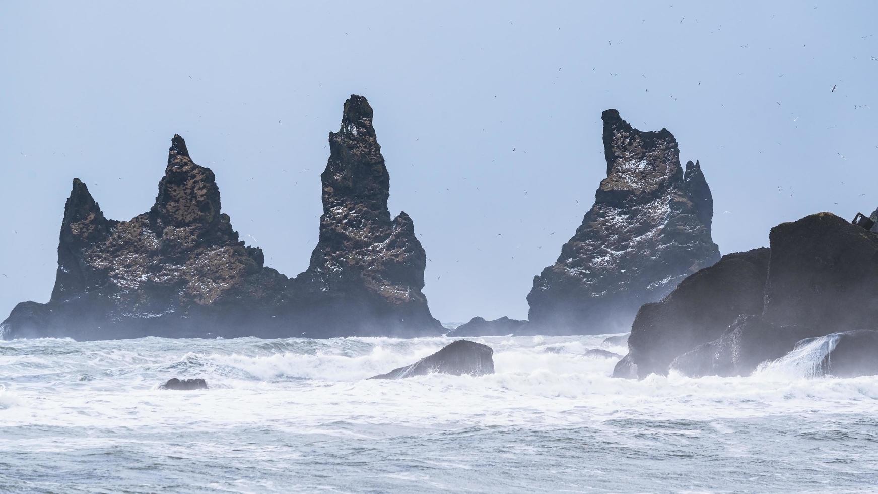 formações de rocha negra no mar foto