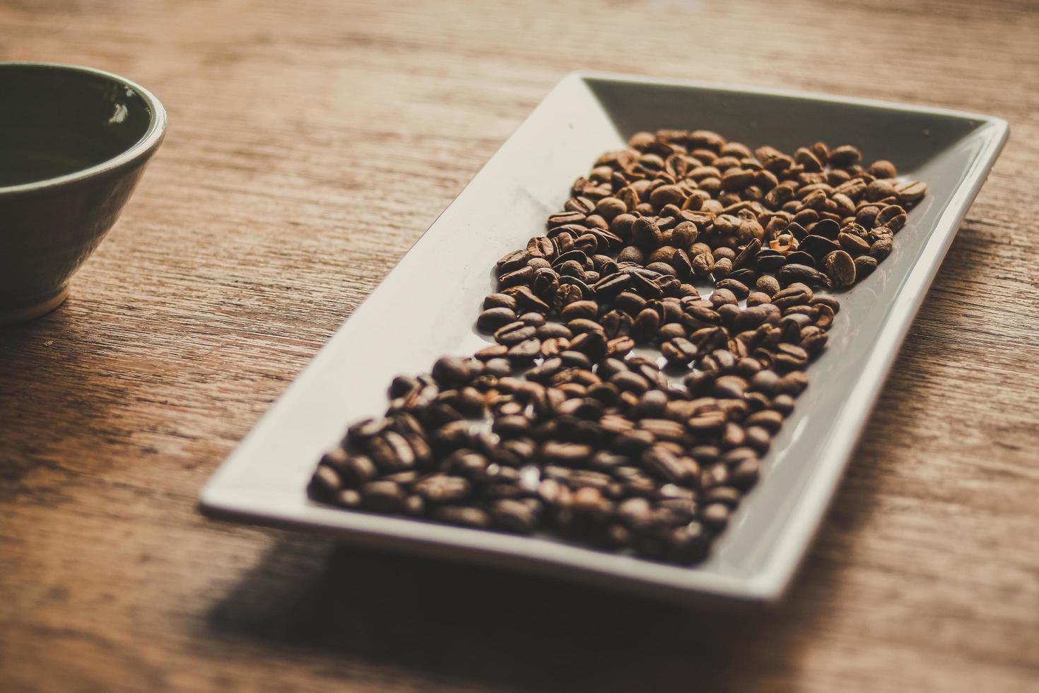 grãos de café marrons em uma bandeja de cerâmica foto