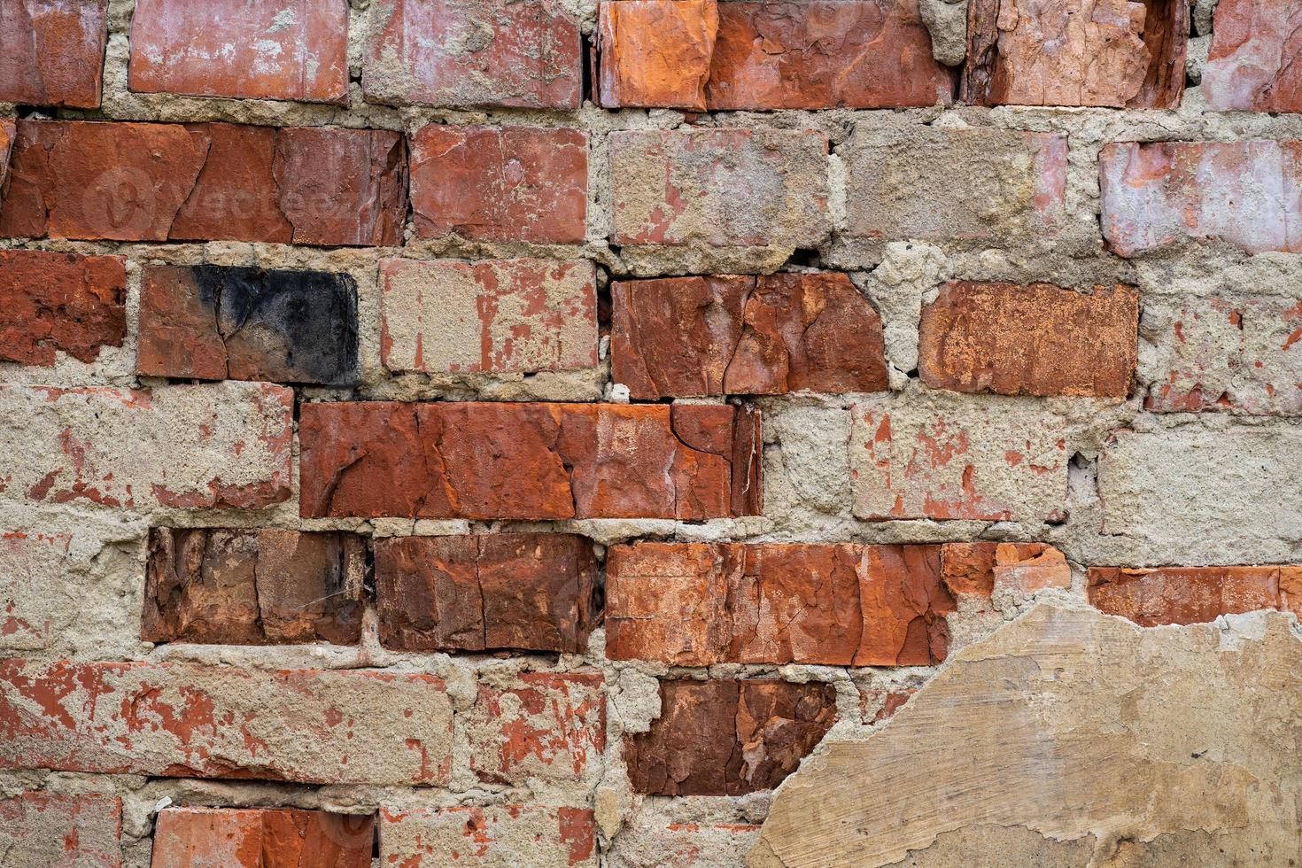 textura da velha parede de tijolo vermelho rachada e destruída foto