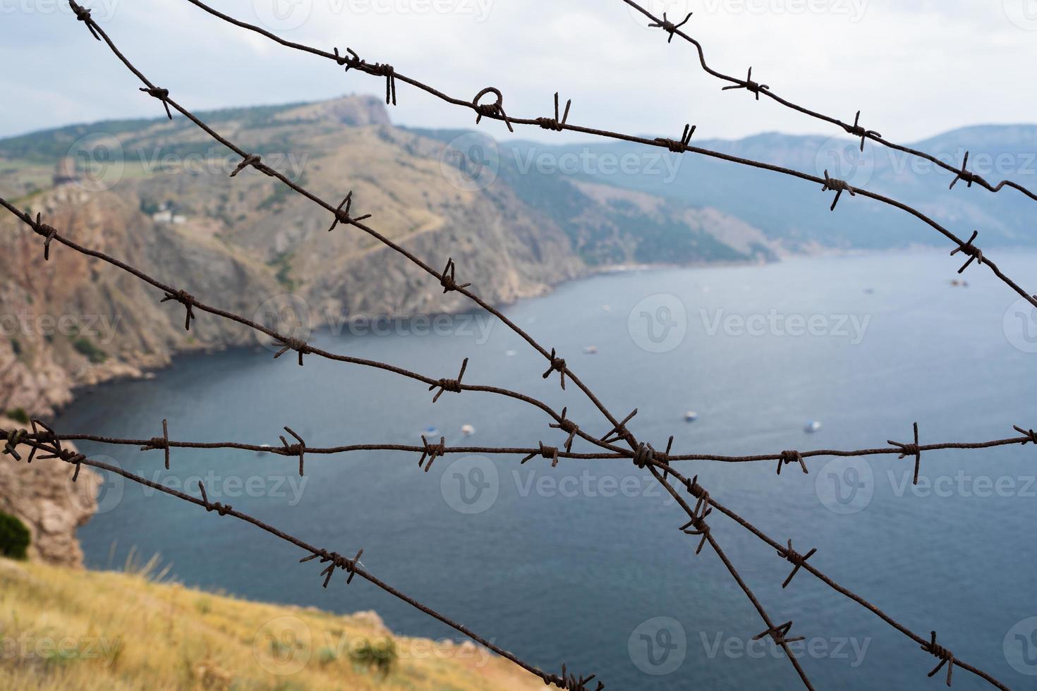 fronteira militar de arame farpado no mar nas montanhas foto