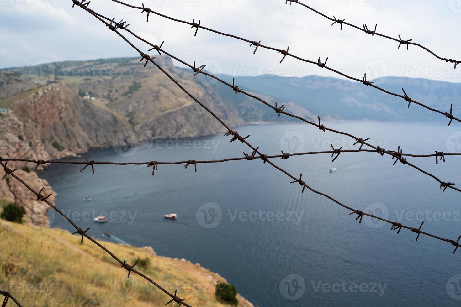 fronteira militar de arame farpado no mar nas montanhas foto