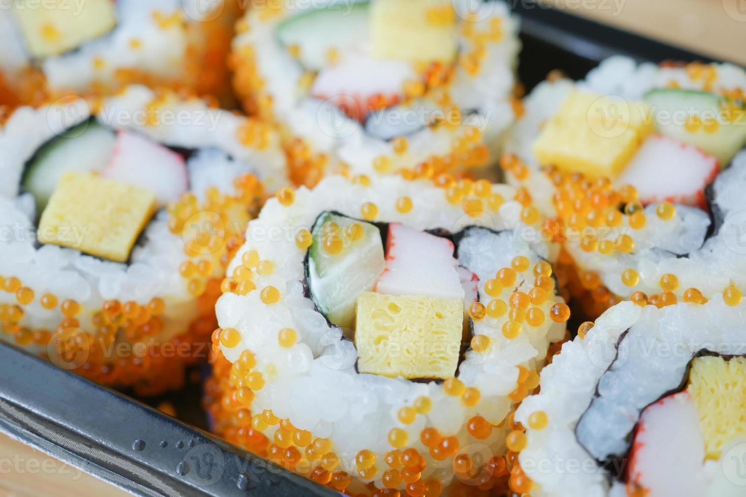 tiro de detalhe de rolo de sushi com salmão, camarão e abacate foto