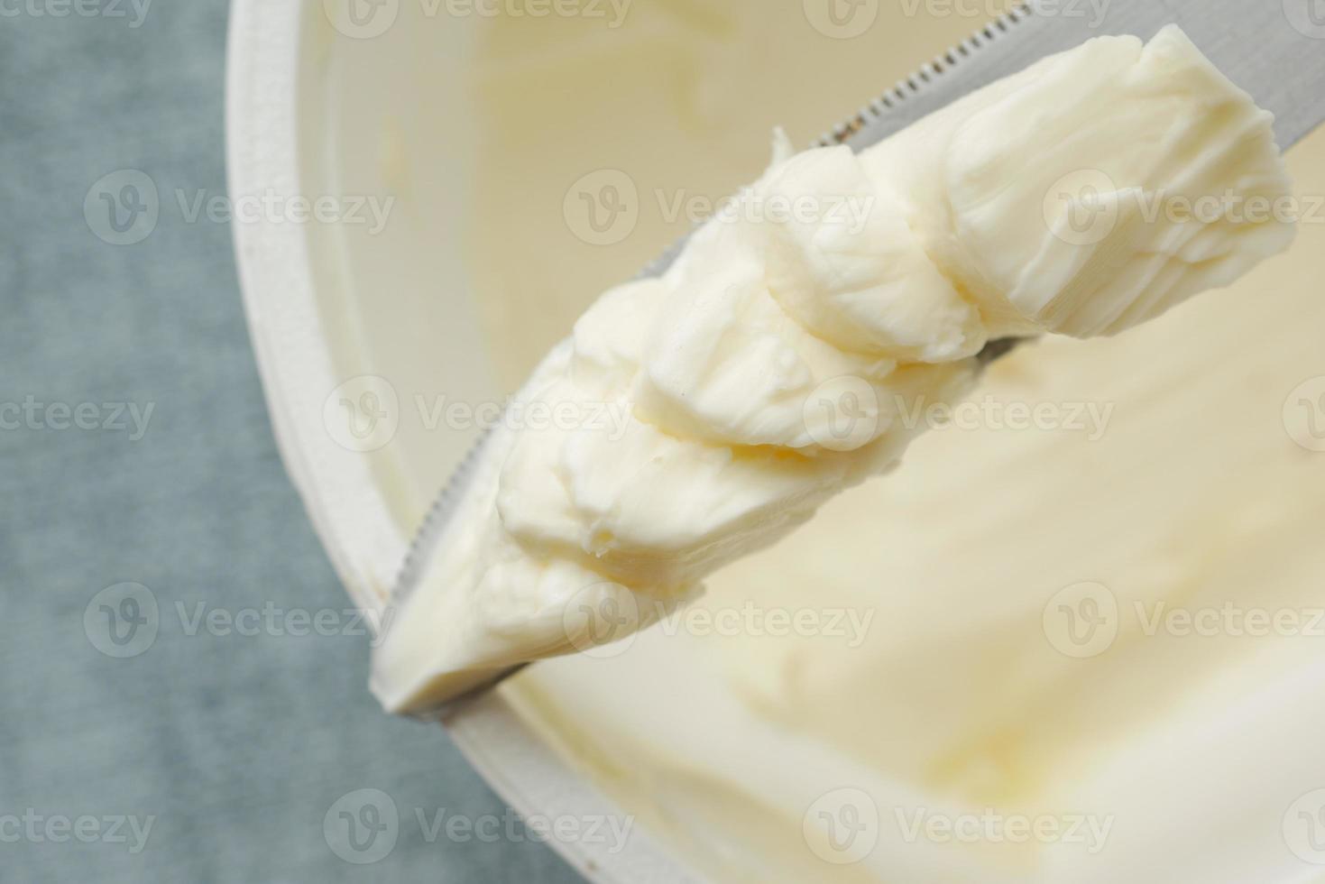 manteiga fresca em um recipiente com pão no fundo branco foto