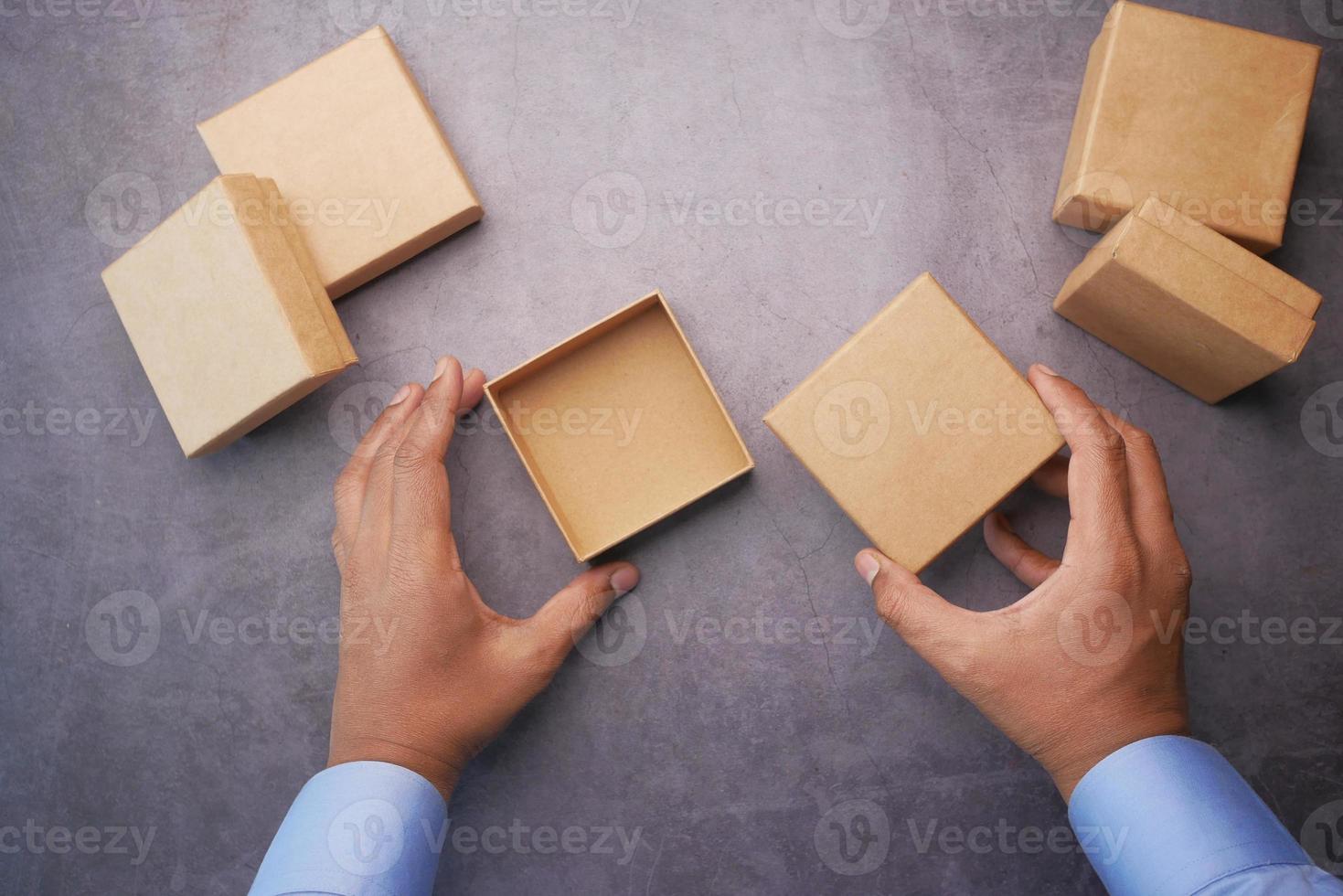 vista superior da pessoa abre uma pequena caixa de presente vazia foto