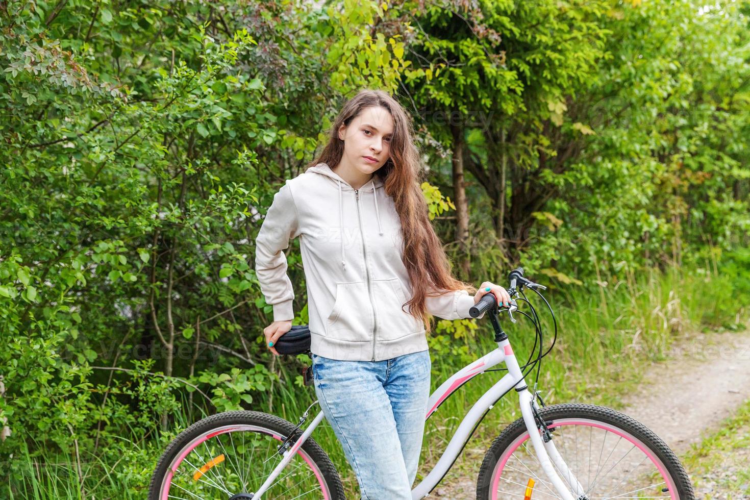 jovem andando de bicicleta no parque da cidade de verão ao ar livre. pessoas ativas. garota hipster relaxar e andar de bicicleta foto