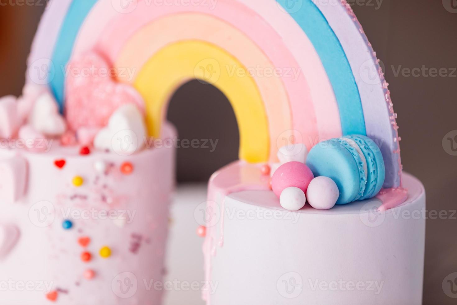 grande bolo de aniversário com arco-íris, granulado colorido. no fundo de muitos balões de coração colorido. festa de aniversário. doce feriado. foto