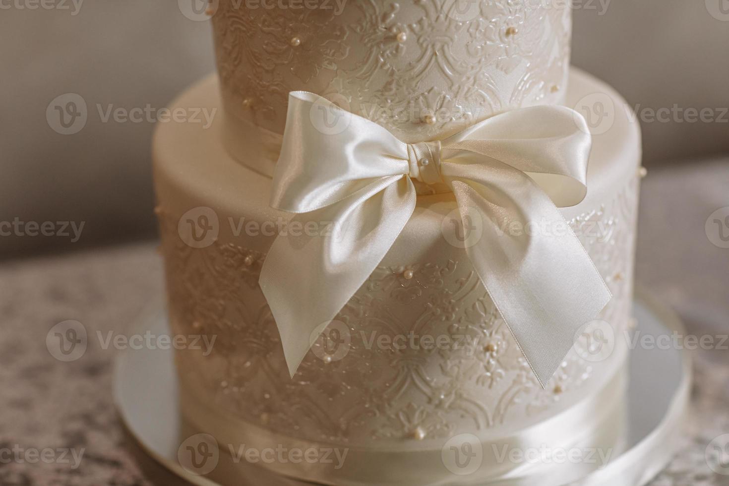 bolo de casamento branco. detalhe do bolo de casamento - uma fita com pérolas. foto