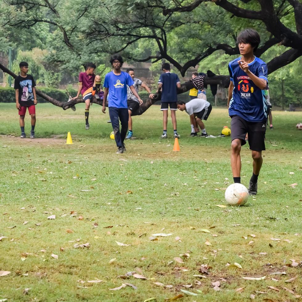 Nova Deli, Índia - 01 de julho de 2018 - jogadores de futebol do time de futebol local durante o jogo no campeonato regional de derby em um campo de futebol ruim. momento quente do jogo de futebol no campo de grama verde do estádio foto