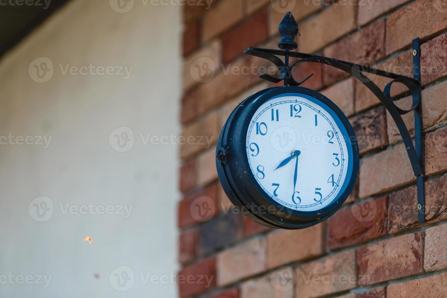 horas antigas, relógio de 7,30 horas na mesa de madeira no jardim verde às horas foto