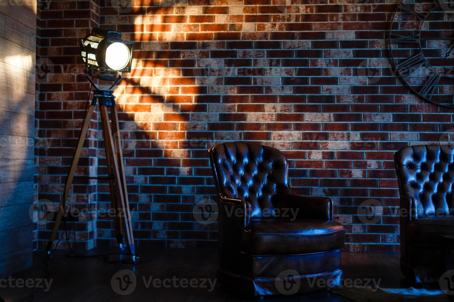 interior do sotão simulado parede de bloco cinza com cadeira de couro e lâmpada de fonte de luz vintage foto