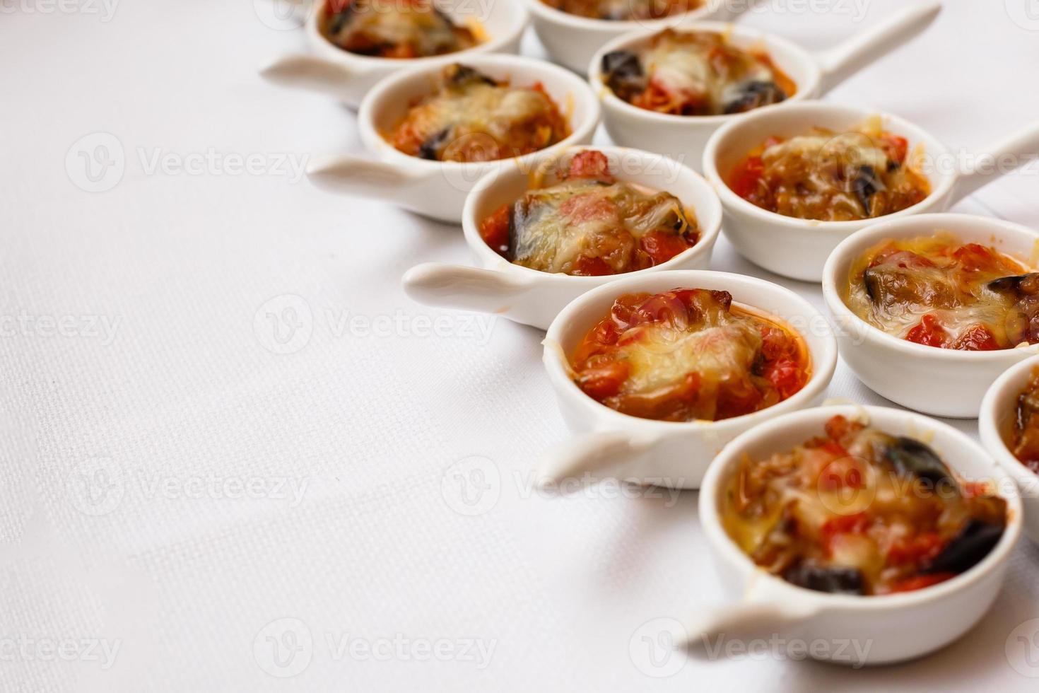 copinhos com legumes em prato branco ficam na mesa do buffet foto