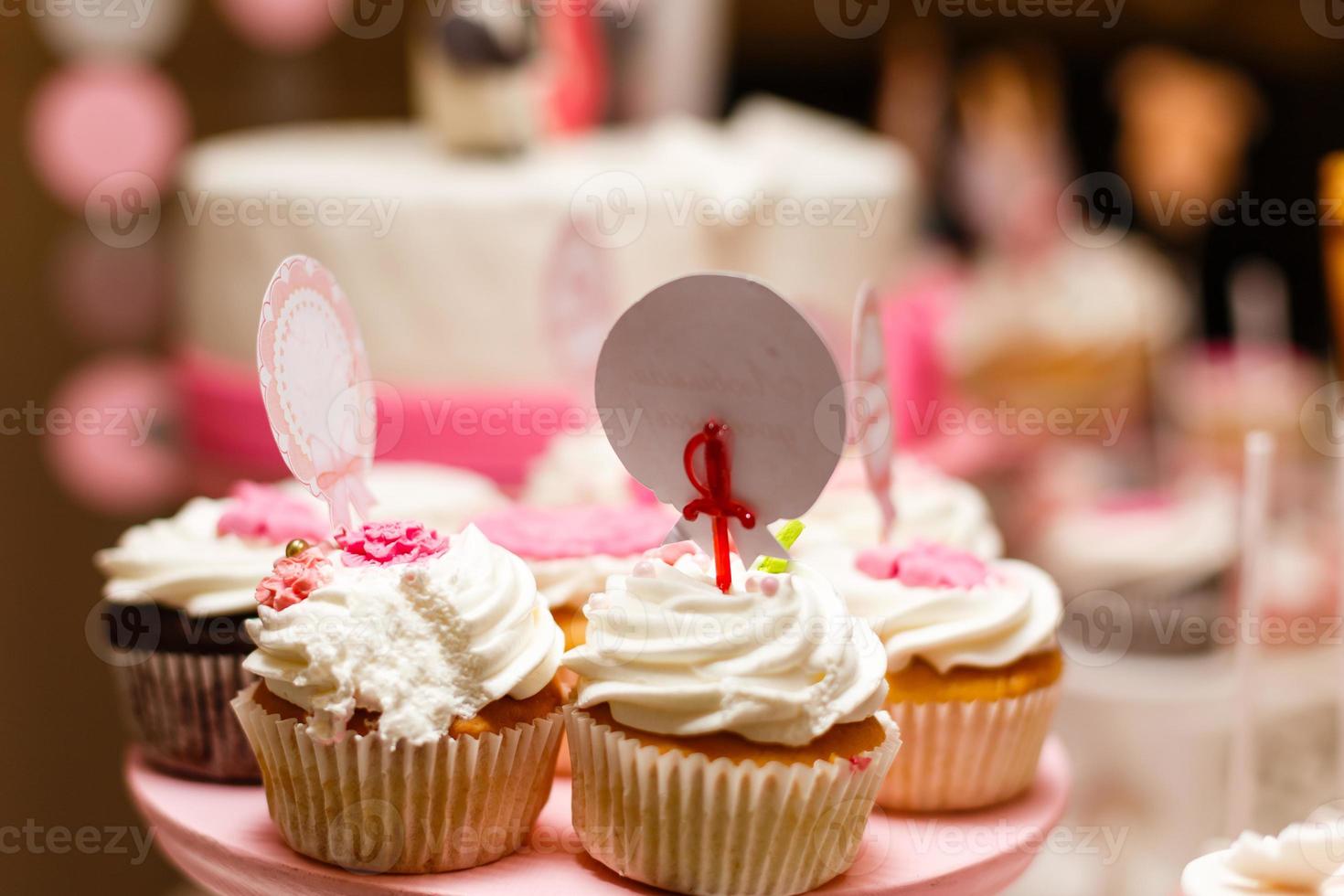 cupcakes de baunilha cobertos com redemoinho de glacê de baunilha doce capturados na mesa foto