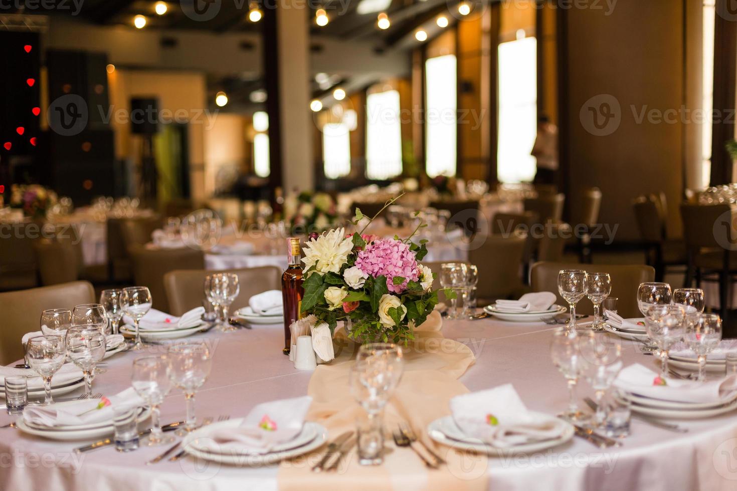 linda mesa com louças e flores para uma festa, recepção de casamento ou outro evento festivo. copos e talheres para jantar de evento servido. foto