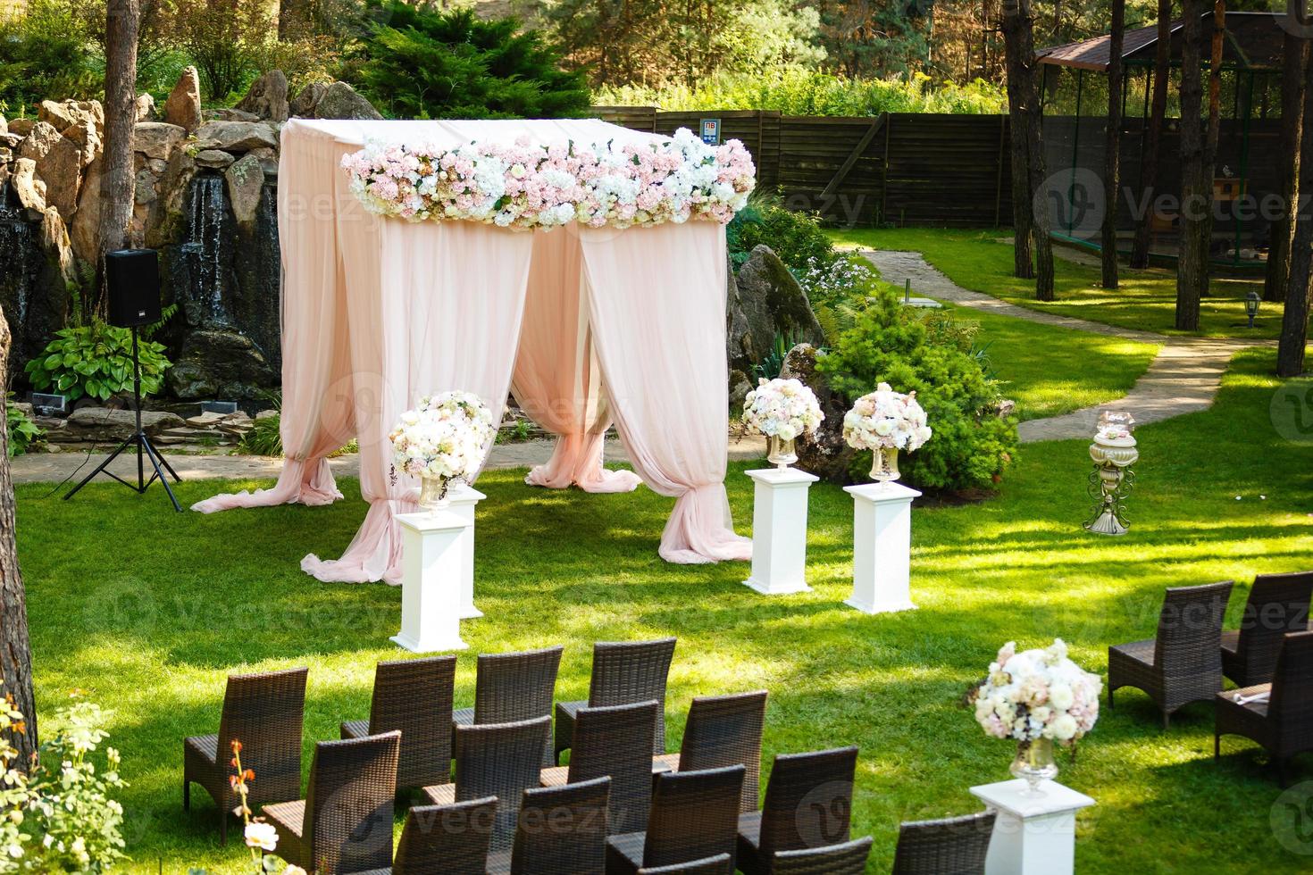 belos elementos de decoração de design de cerimônia de casamento com arco, design floral, flores e cadeiras. foto