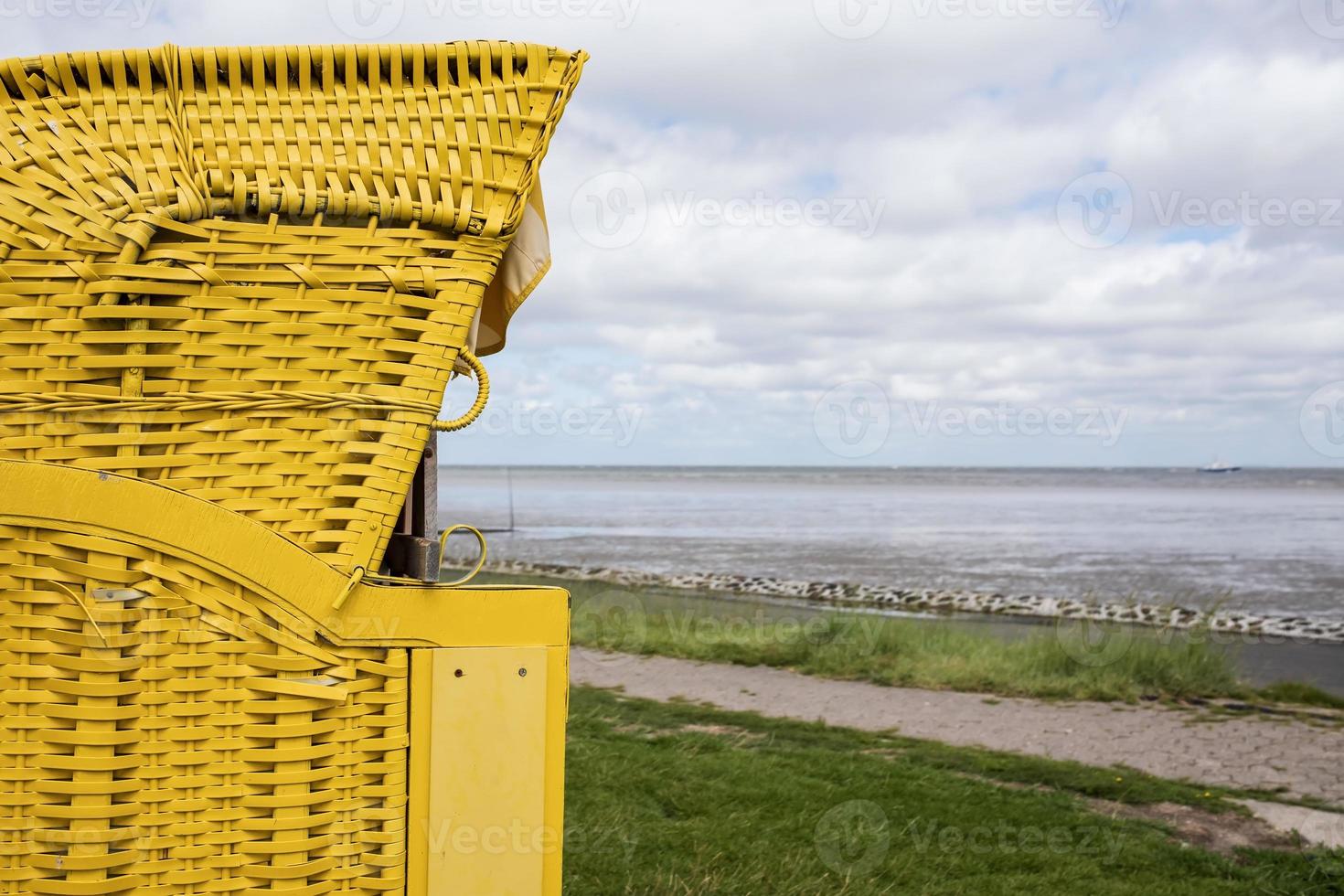 cadeira de vime tendo como pano de fundo uma paisagem marítima. mobiliário de exterior para lazer, no litoral. foto