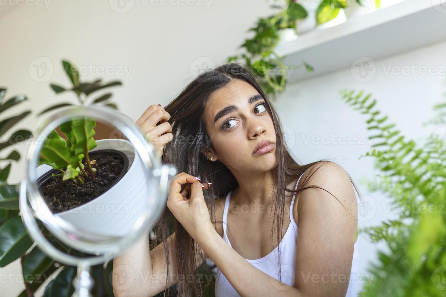 retrato de uma garota nervosa e chateada, passando os dedos pelos cabelos e pensando em caspa e perda de cabelo com emoções tristes. conceito de problema de perda de cabelo foto