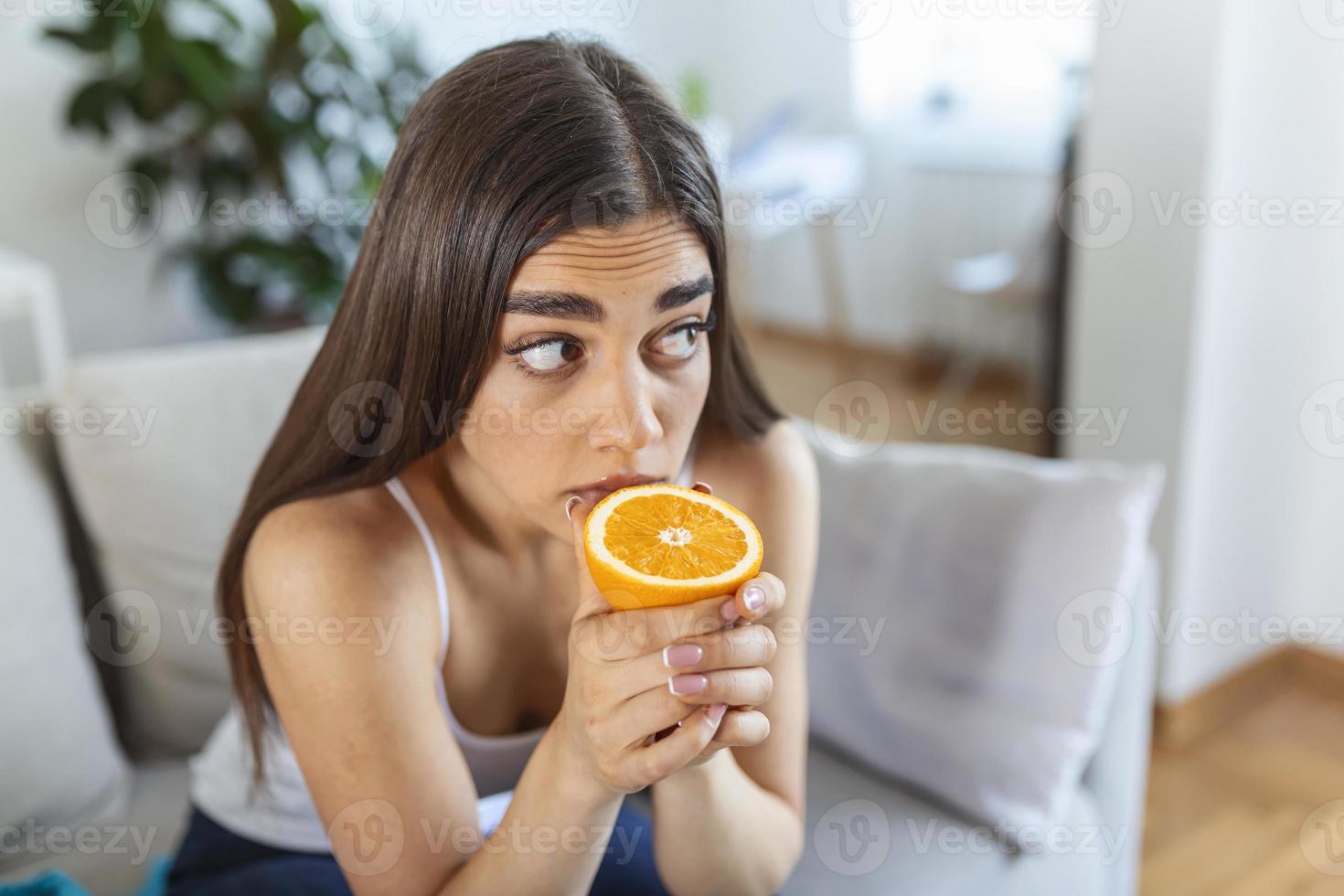 mulher doente tentando sentir o cheiro de meia laranja fresca, apresenta sintomas de covid-19, infecção pelo vírus corona - perda de olfato e paladar. um dos principais sinais da doença. foto