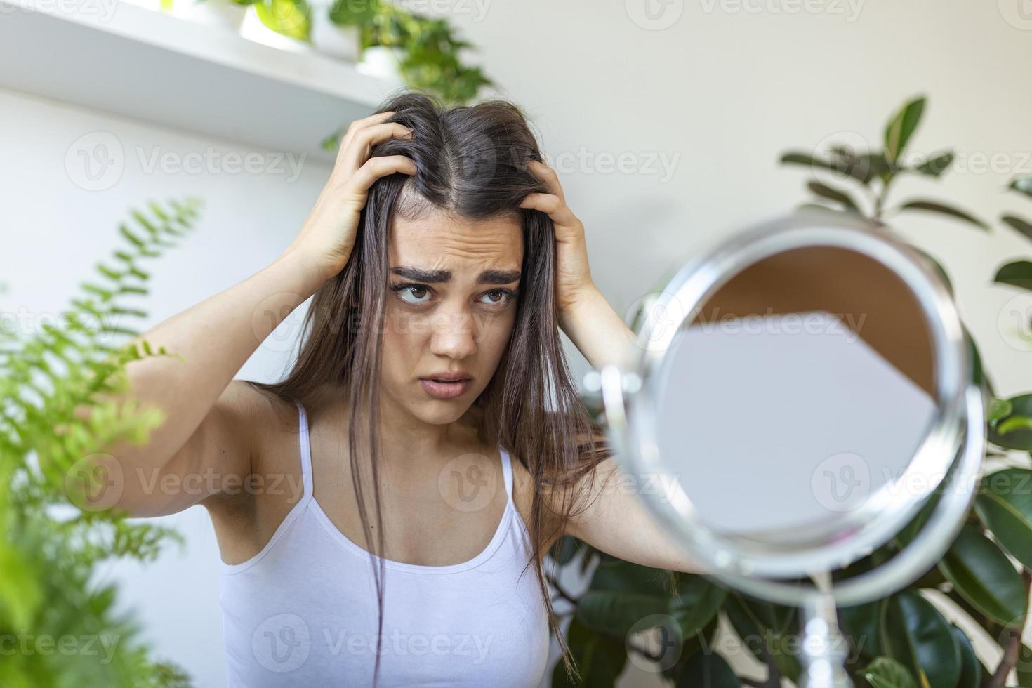 retrato de uma garota nervosa e chateada, passando os dedos pelos cabelos e pensando em caspa e perda de cabelo com emoções tristes. conceito de problema de perda de cabelo foto