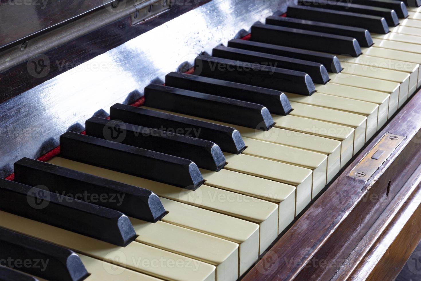 feche as teclas pretas e brancas de um piano vintage. foco seletivo foto