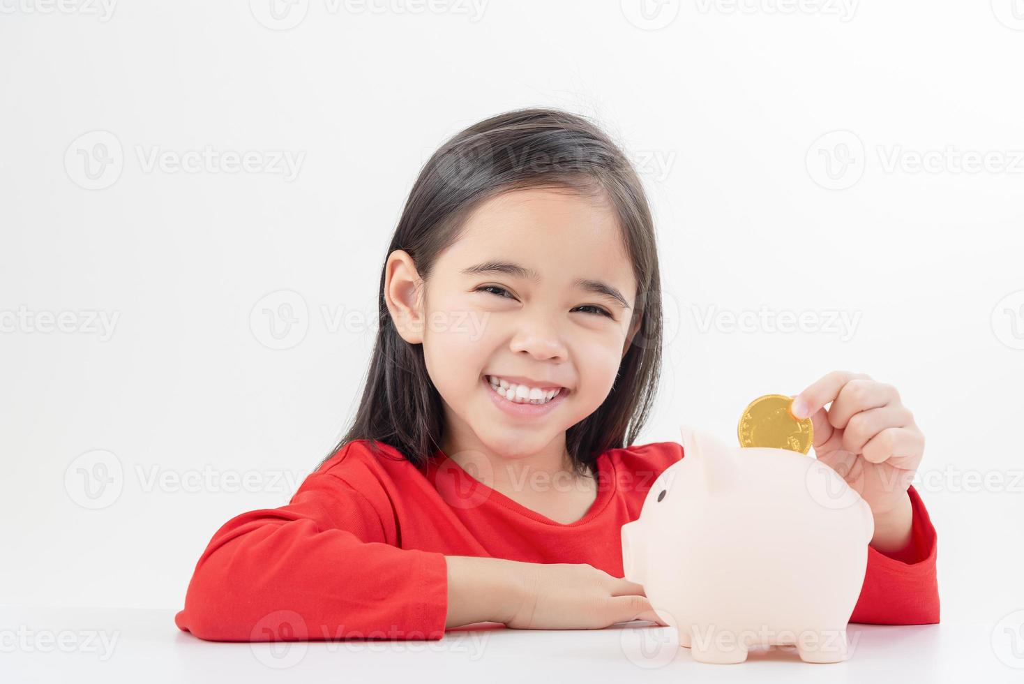 menina asiática economizando dinheiro em um cofrinho, aprendendo sobre economia, criança economizando dinheiro para educação futura. conceito de dinheiro, finanças, seguro e pessoas foto