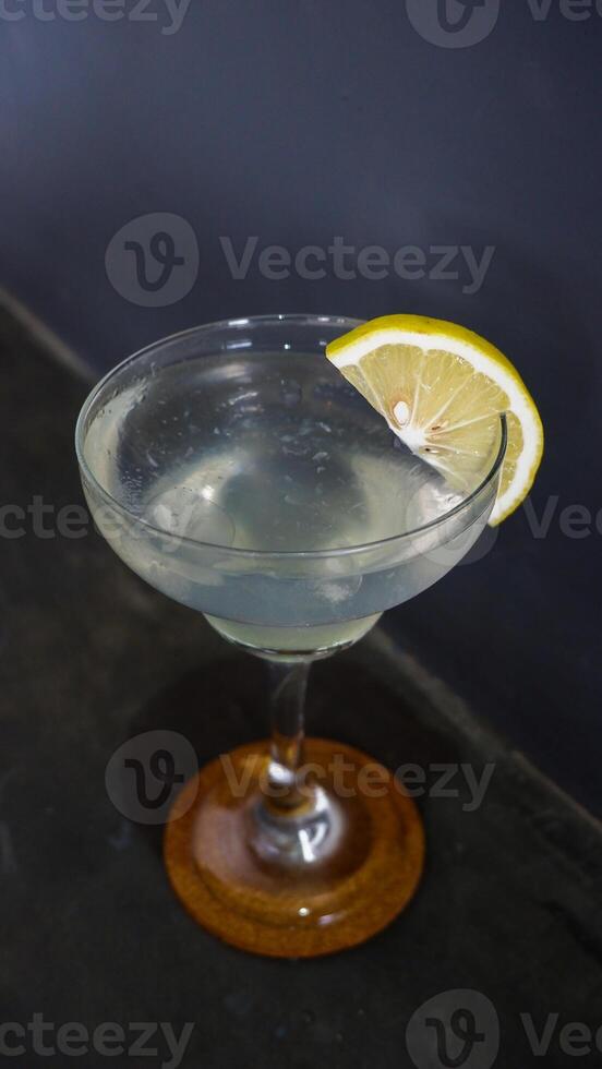 limonada. bebida espumante refrescante em um copo elegante decorado com uma rodela de limão foto