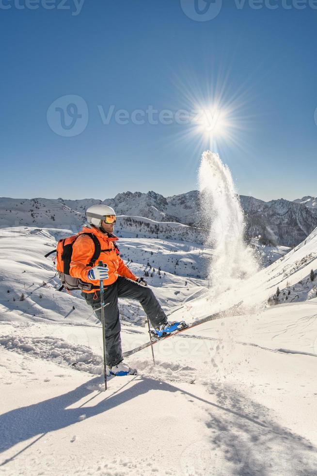 esquiador fora de pista levanta neve em esquis foto