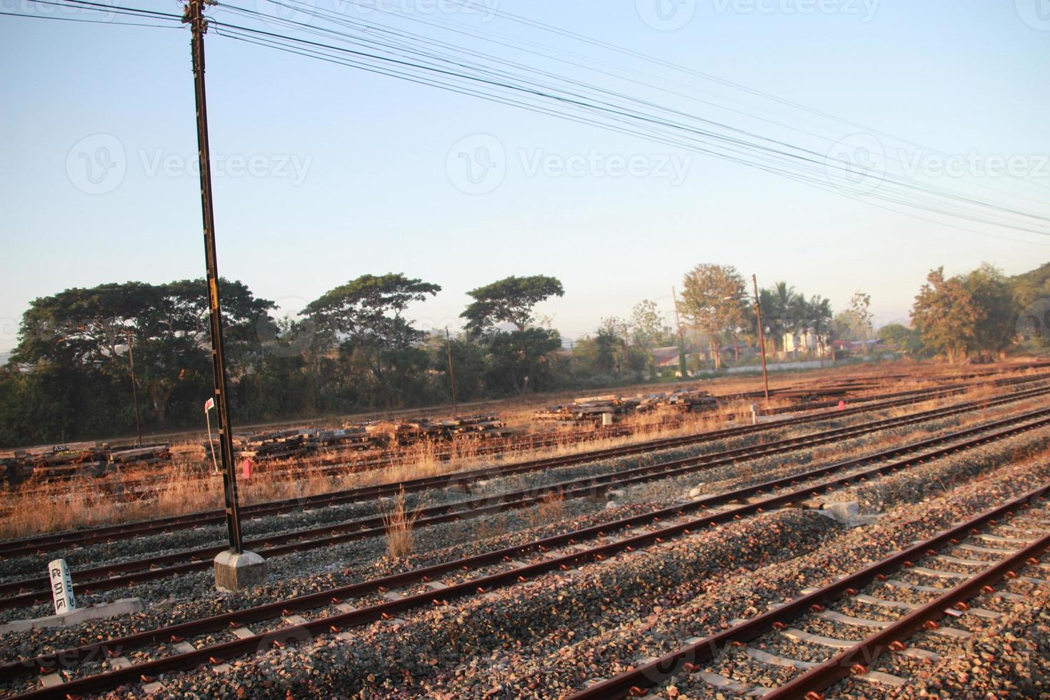 trilhos de trem da janela externa na zona rural com céu pôr do sol foto