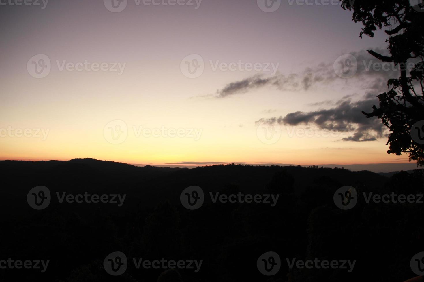 nascer e pôr do sol nas montanhas com árvores e nuvens céu crepúsculo crepúsculo tempo foto