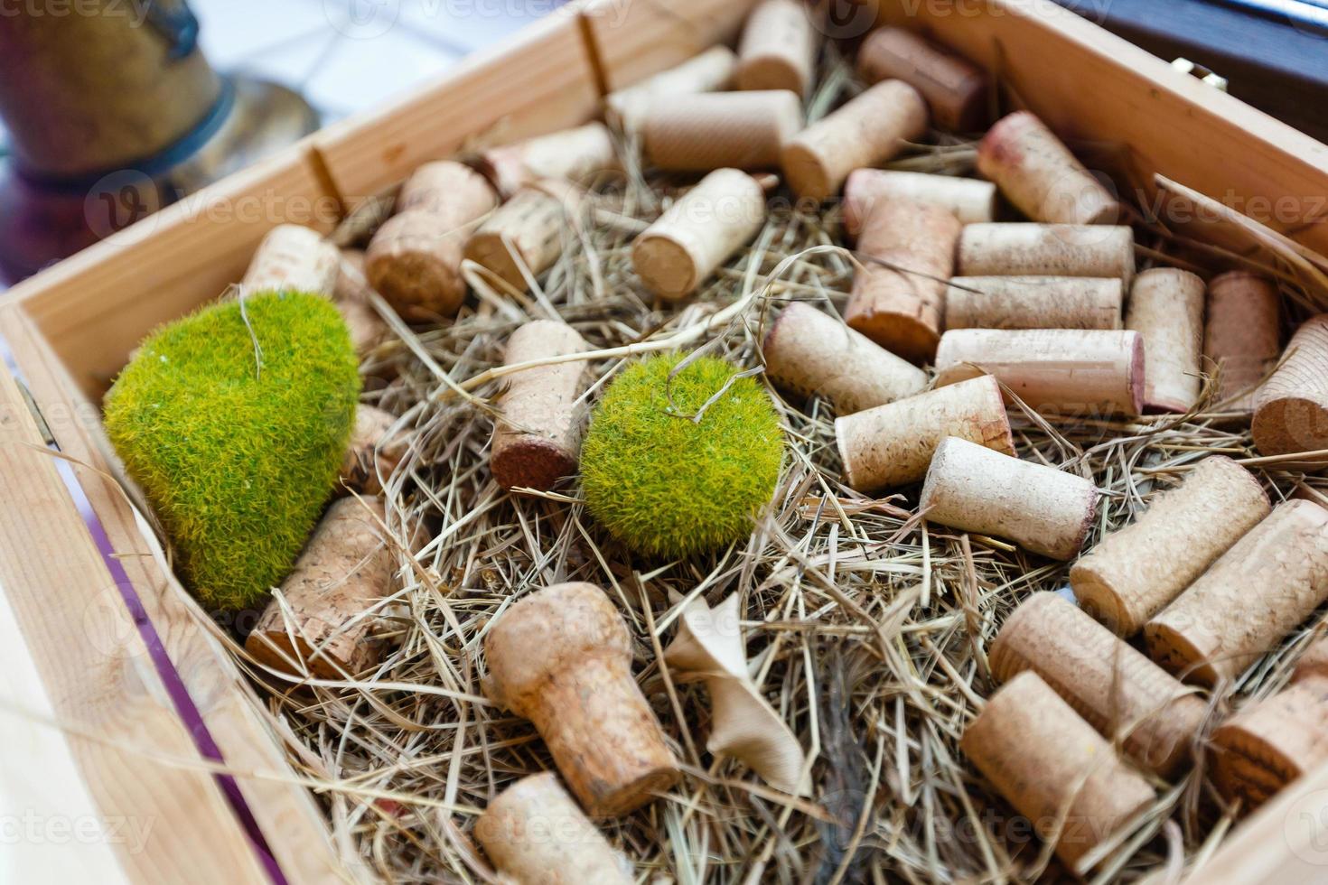 cacho de uvas pretas ou vermelhas exibidas na palha em uma caixa de madeira cercada por rolhas conceituais de viticultura e vinificação foto