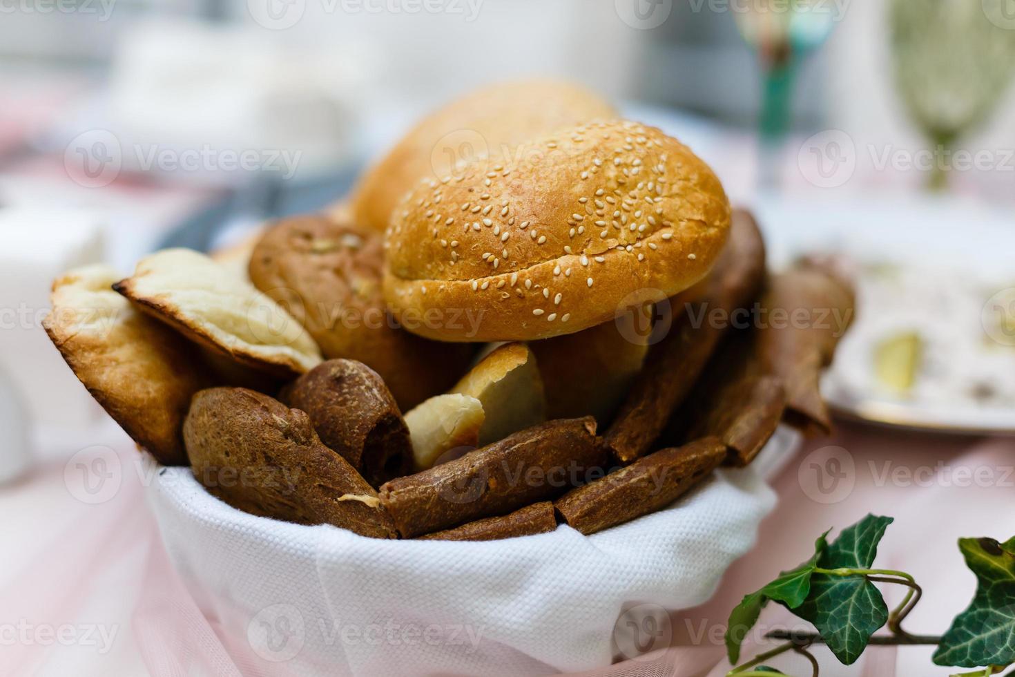 pão na cesta com manteiga sob a luz do sol pãezinhos pão na mesa da cesta foto