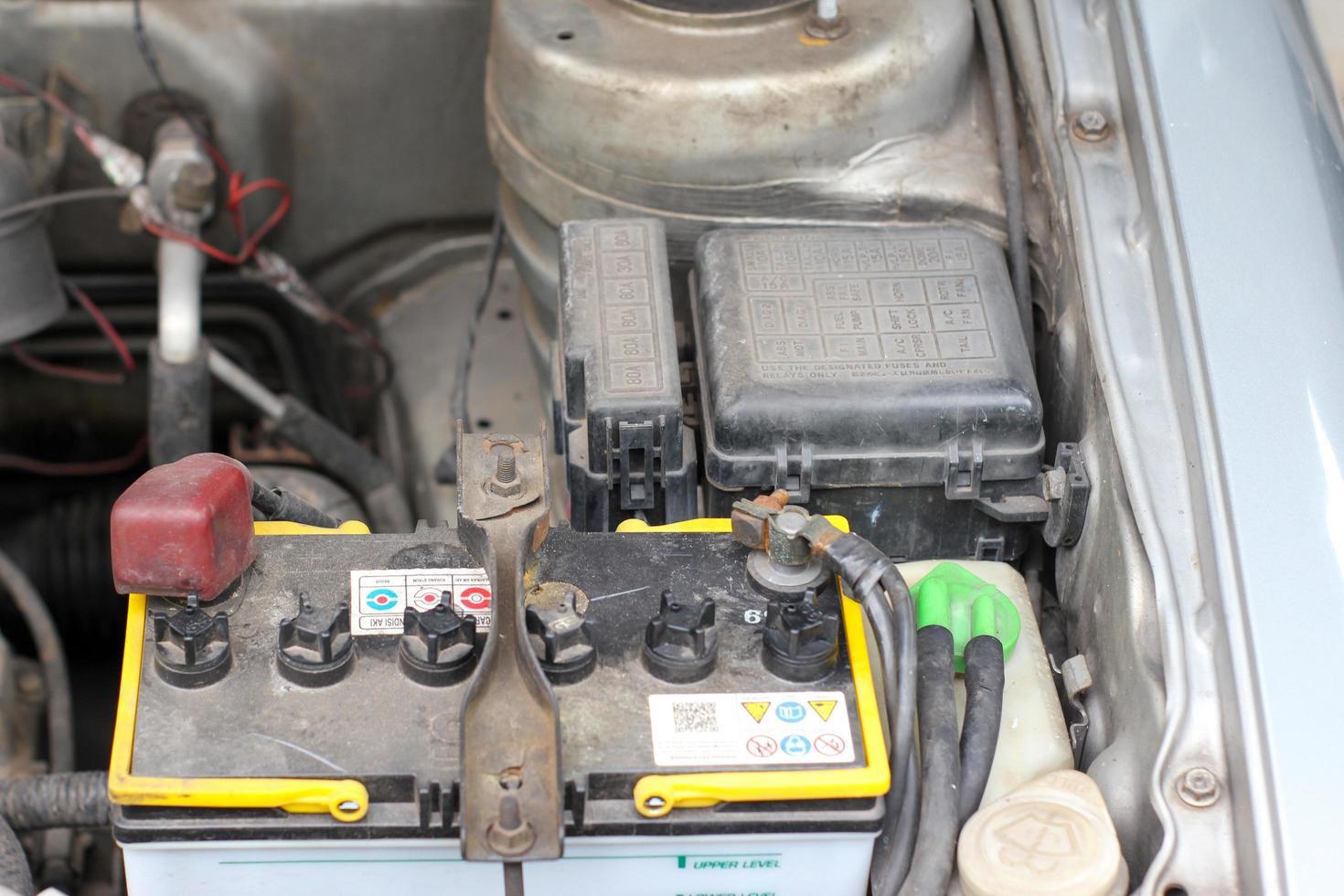 bateria e caixa de fusíveis na sala do motor do carro antigo foto