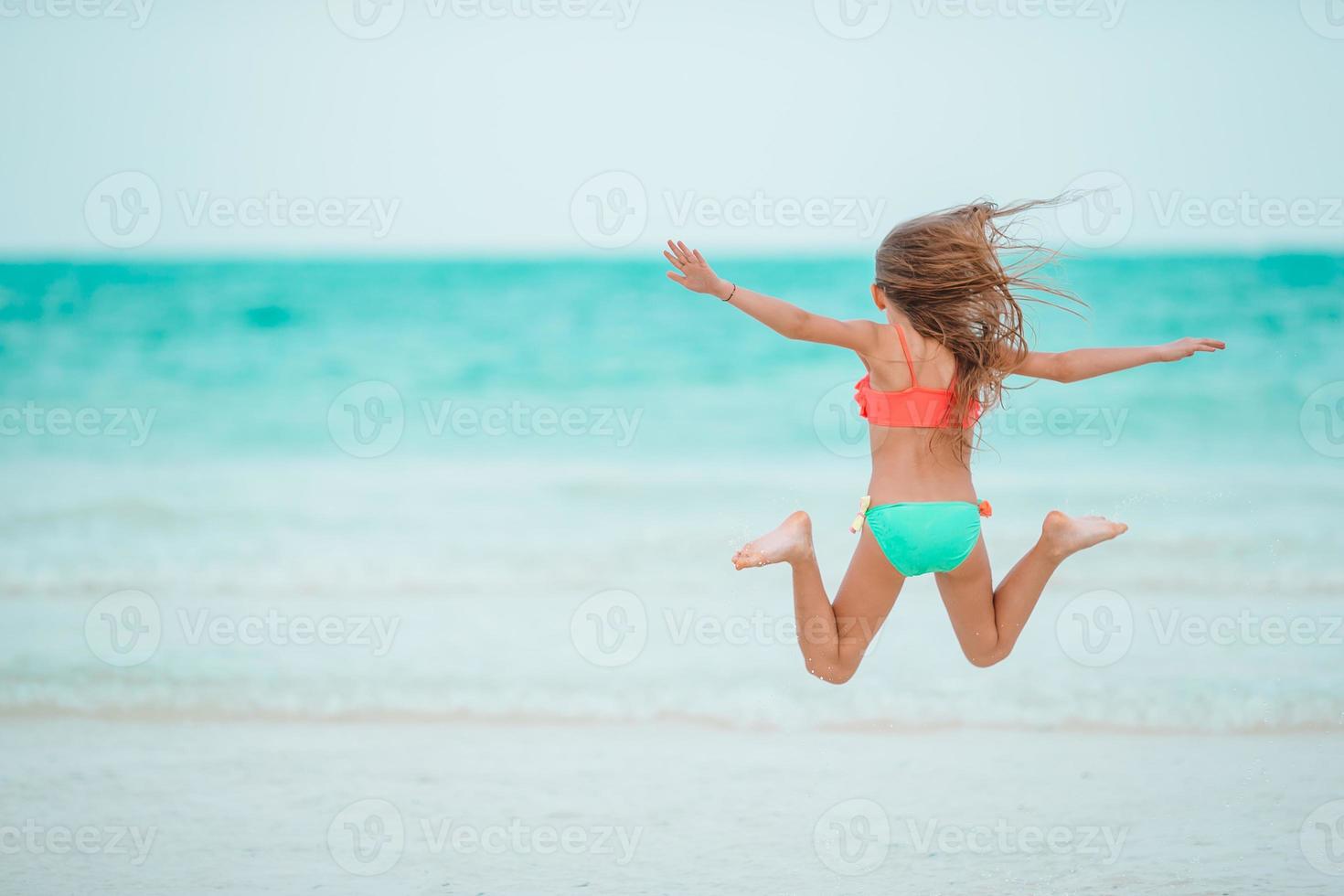 menina adorável na praia durante as férias de verão foto