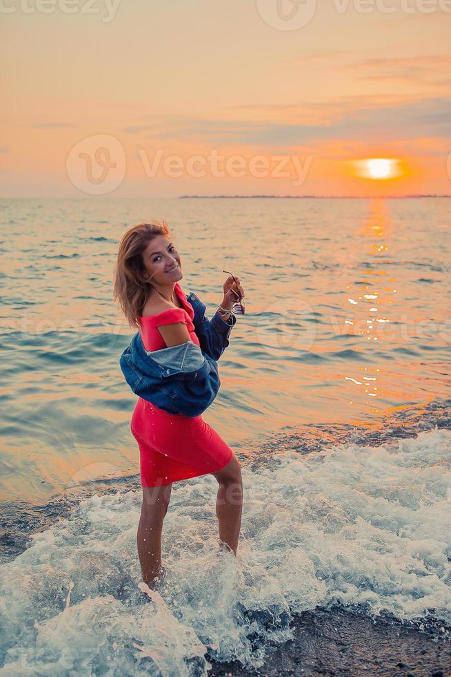 retrato de moda ao ar livre da menina elegante vestindo jaqueta jeans na praia. foto