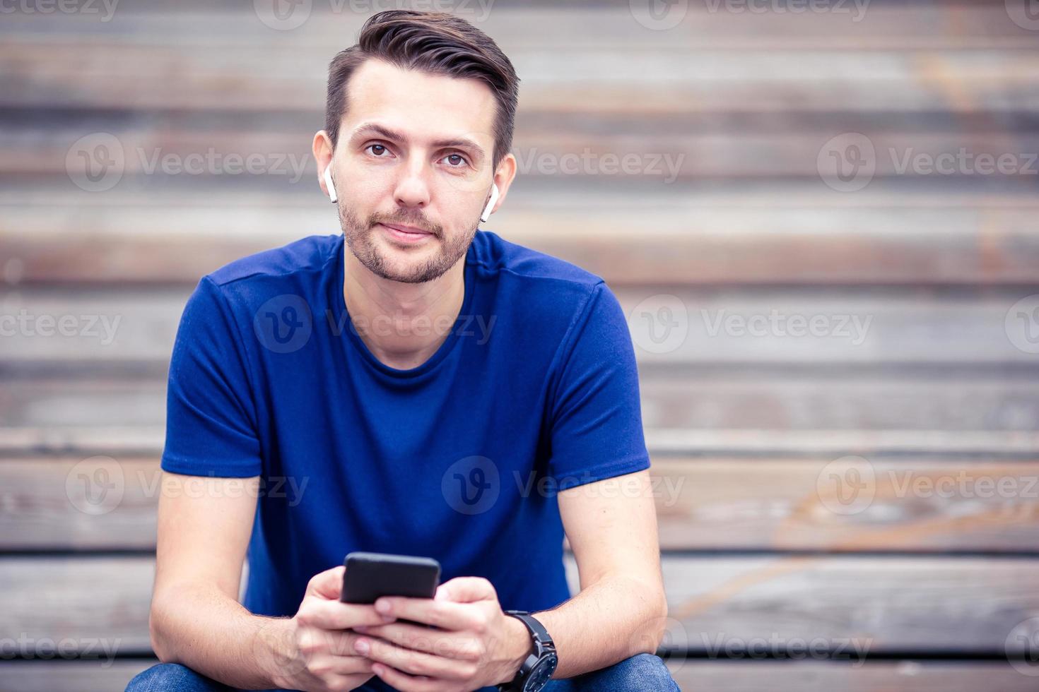 homem está lendo mensagem de texto no celular enquanto caminhava no parque foto