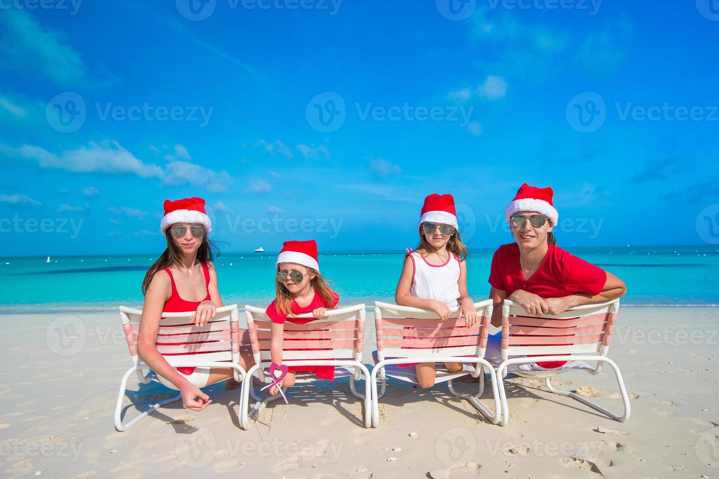 família feliz com dois filhos com chapéu de Papai Noel nas férias de verão foto