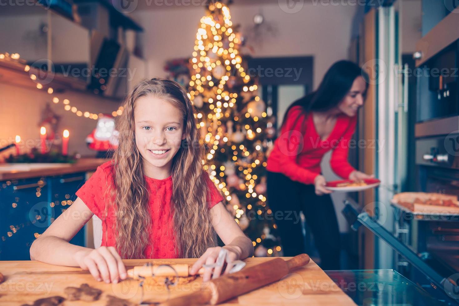 adorável menina assando biscoitos de gengibre de natal foto