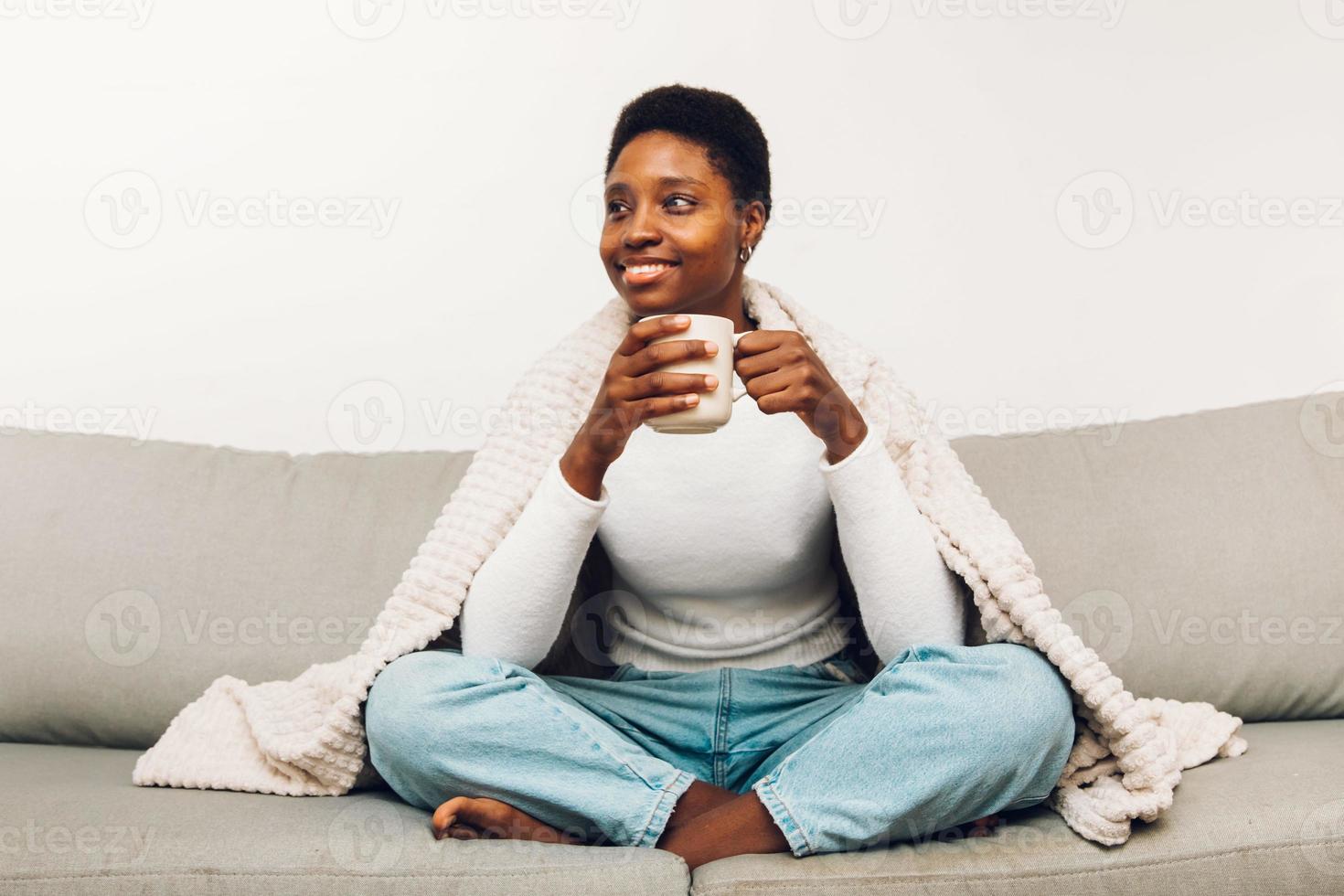 pessoa sentada em um sofá e tomando café foto