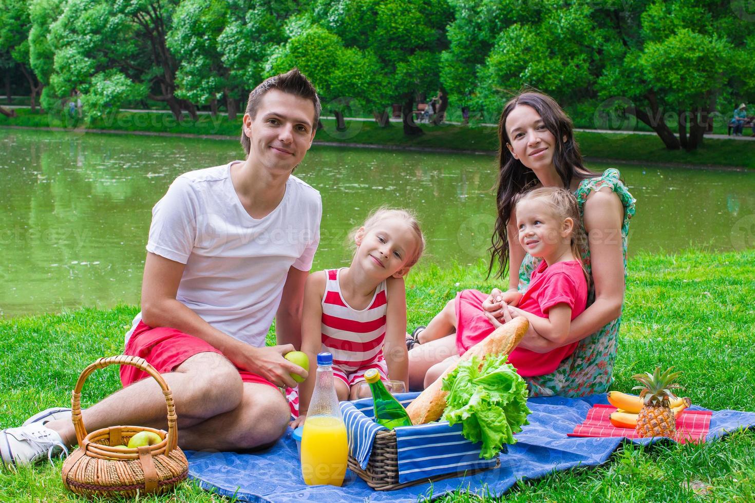 família feliz fazendo piquenique no parque foto