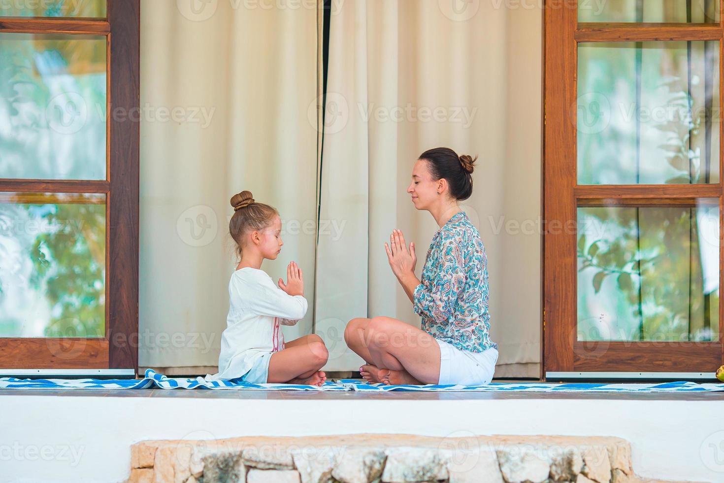 família jovem feliz meditando no terraço foto