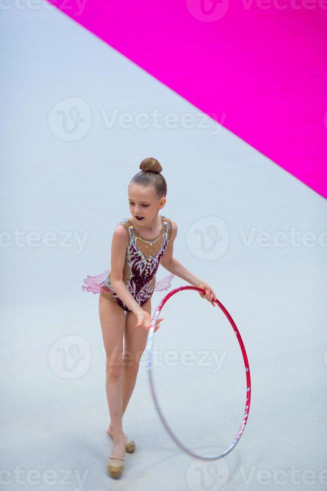 pequena ginasta treinando no tapete e pronta para competições foto