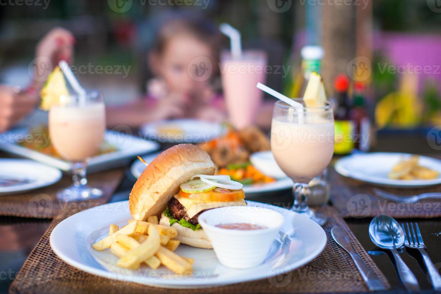 hambúrguer e batatas fritas na chapa branca para o almoço foto