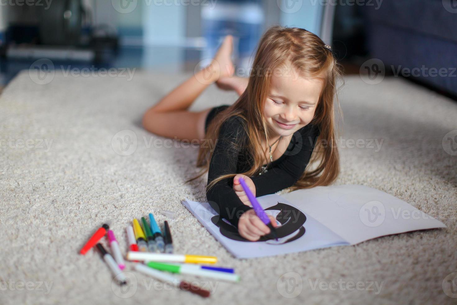 retrato de uma doce e encantadora jovem que desenha com sua coloração em casa foto