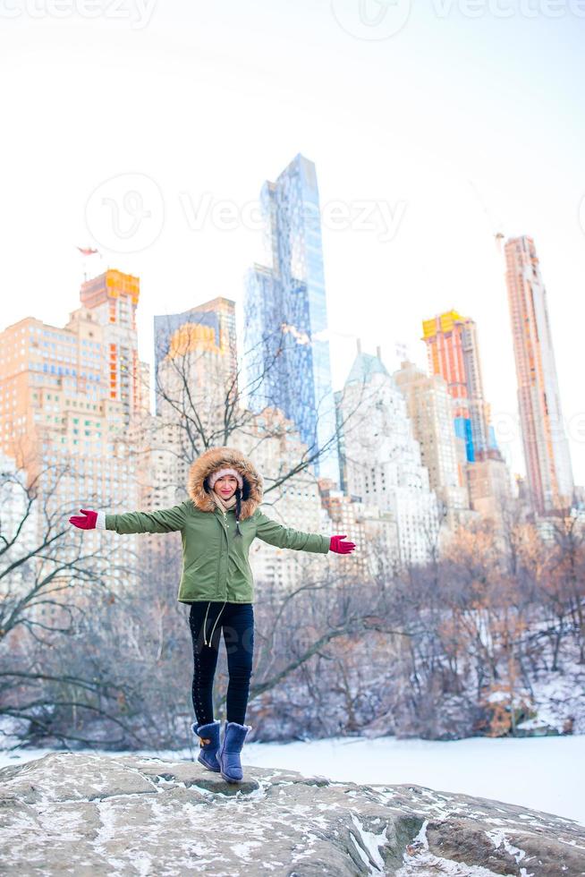 menina adorável com vista para a pista de gelo no central park em manhattan na cidade de nova york foto