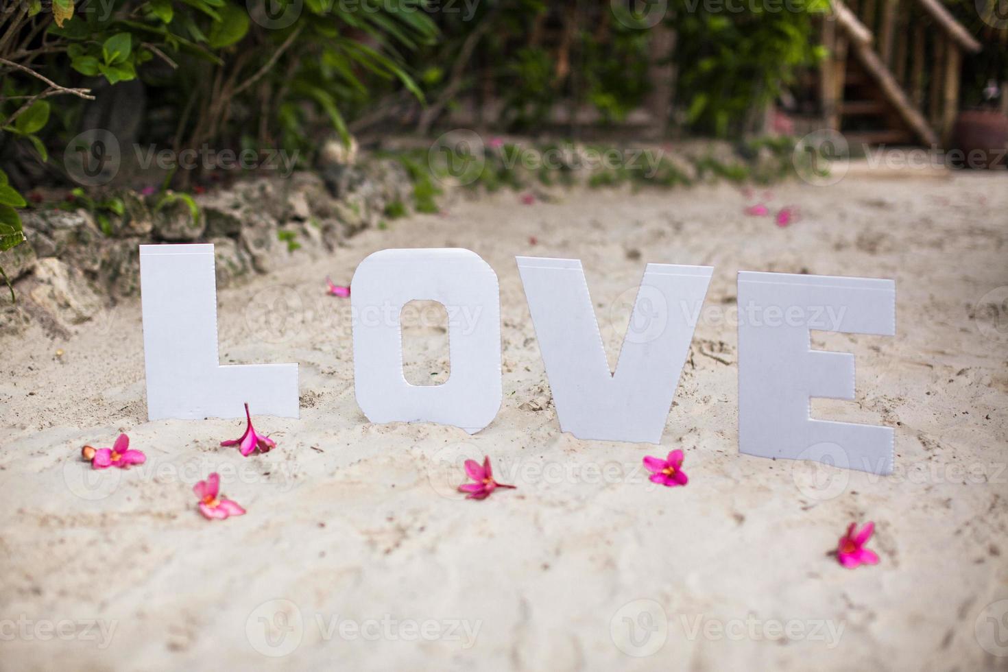 palavra amor na praia de areia no belo resort foto
