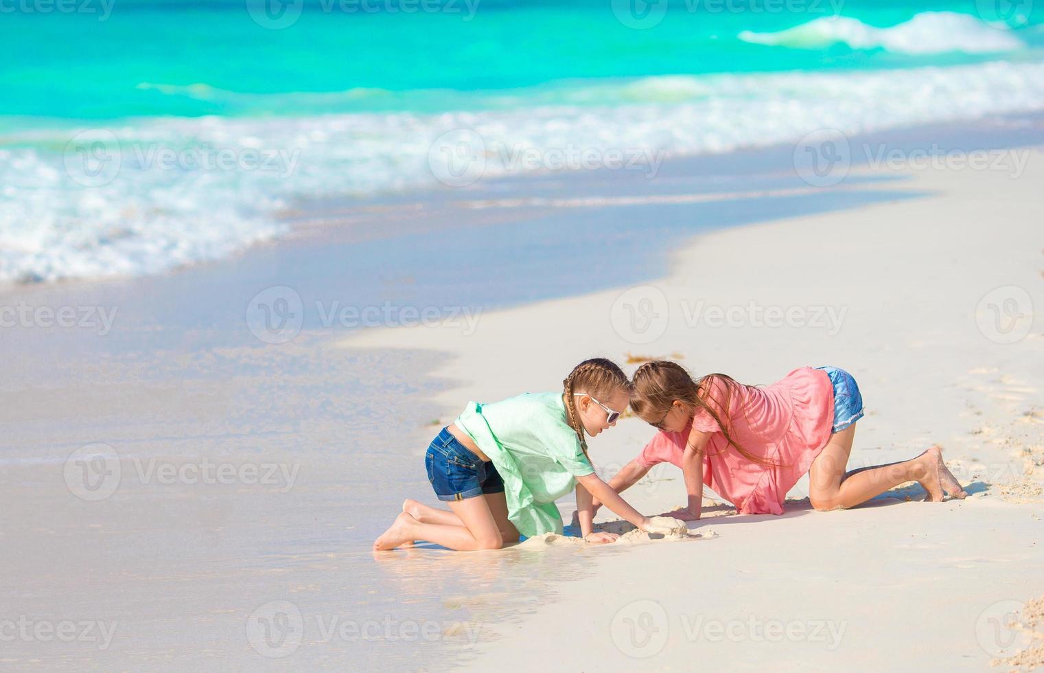 adoráveis crianças brincam juntas na praia foto