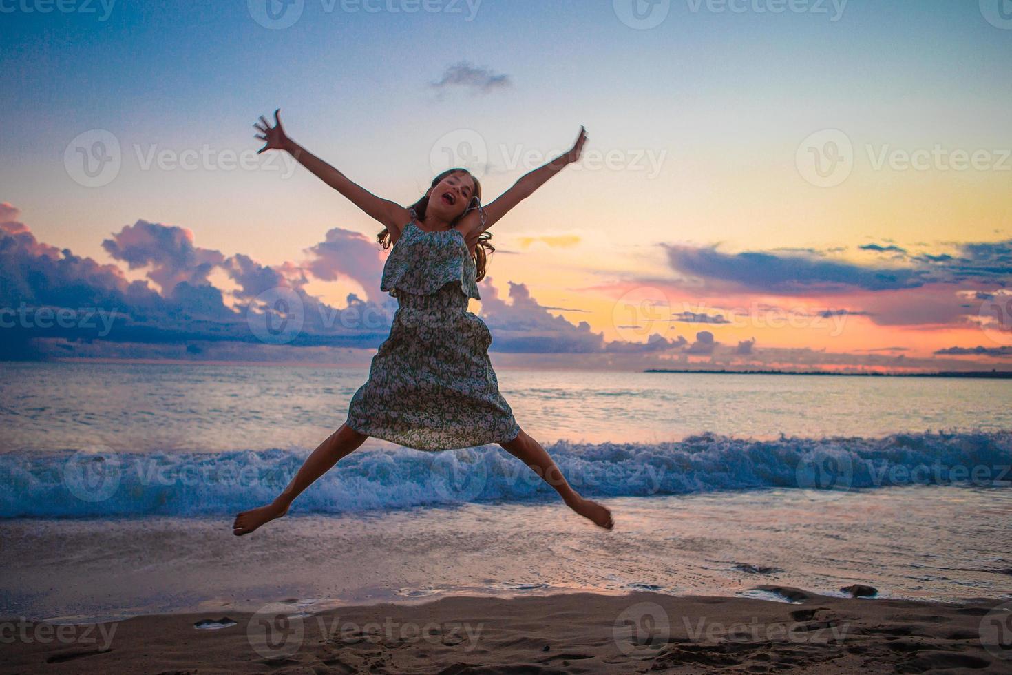 menina engraçada feliz se diverte muito na praia tropical brincando juntos foto