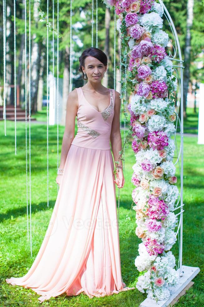 linda jovem em um vestido longo na cerimônia ao ar livre foto